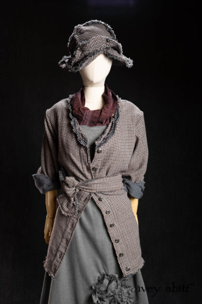 Bonheur Hat in Pewter and Amethyst Houndstooth Wool; Chevallier Frock in Pewter Cashmere Cotton Twill; Heirloom Sash in Amethyst Embroidered Puckered Organza; Bonheur Shirt Jacket in Pewter and Amethyst Houndstooth Wool. - Bespoke clothing by Ivey Abitz.