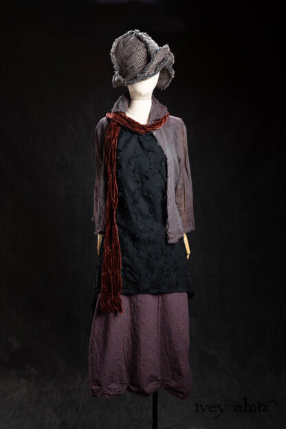Bonheur Hat in Pewter and Amethyst Houndstooth Wool; Sollie Shirt in Amethyst and Pewter Washed Voile; Tollie Sash in Amethyst Silk Velvet; Ardsley Frock in Black Diamond Rustic Embroidered Floral Weave; Limited Edition Gilbert Cardigan in Earth and Iron Petite Stripe Knit; Celia Skirt in Amethyst Flannel Backed Plaid; Bonheur Brooch in Black Sculpted Felt. - Bespoke clothing by Ivey Abitz.