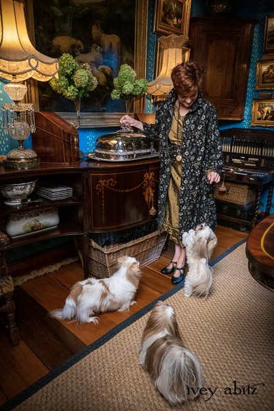 Limited Edition Phinneus Coat in Black Diamond and Pewter Floral Brocade; Porte Cochere Sash in Black Diamond and Pewter Floral Brocade; Inglenook Frock in Brass Crushed Silk; Cilla Slip Frock in Signature Black Washed Silk Jersey Knit; Heirloom Necklace. - Bespoke clothing by Ivey Abitz. Featuring Carolyn Hennesy with rescue dogs and cats.