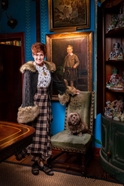 Amelia Jacket in Earth Medieval Knit; Ellis Shirt in Blue Kyanite and Pearl Floral Weave; Cilla Slip Frock in Signature Black Silk Jersey Knit; Fairholme Skirt in Copper and Kyanite Plaid Wispy Wool. - Bespoke clothing by Ivey Abitz. Featuring Carolyn Hennesy with rescue dogs and cats.