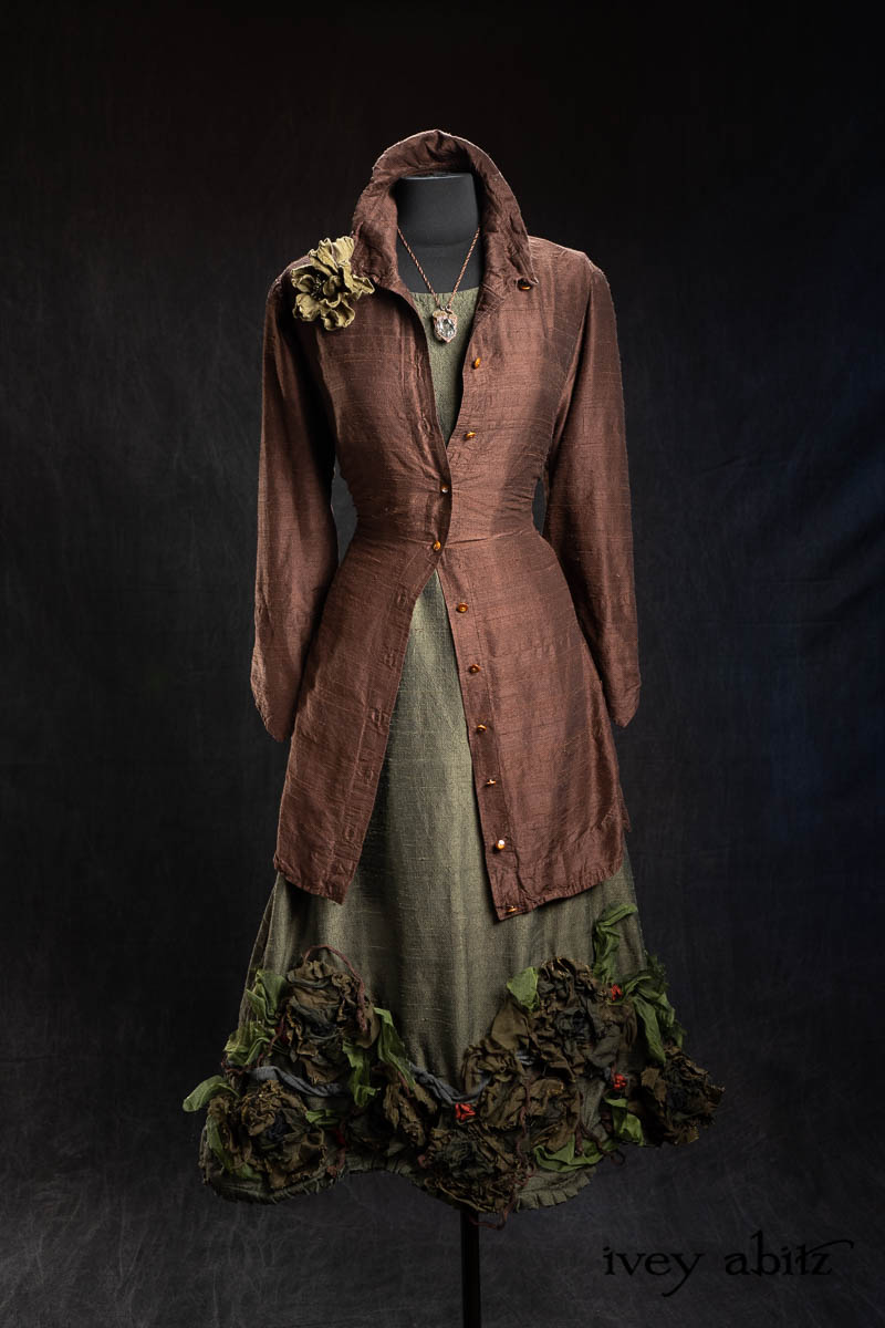 Vanetten Shirt in Earth Washed Textured Silk; Heirloom Necklace; Bonheur Brooch in Olive Quartz Sculpted Felt; Porte Cochere Sash in Olive Quartz Washed Textured Silk; Limited Edition Idyll Frock in Olive Quartz Washed Textured Silk with Handsculpted Floral Embellishments. - Bespoke clothing by Ivey Abitz.