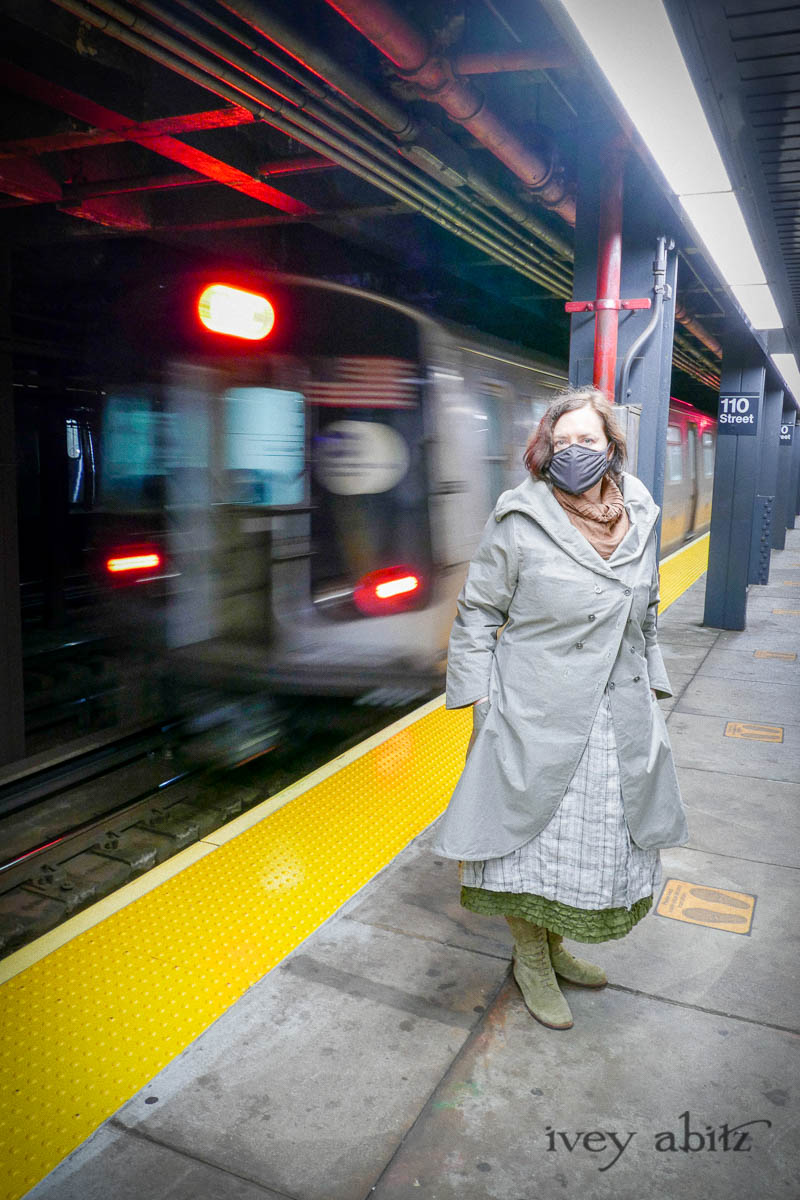 Eleanora Duster Coat in Slate Petite Check Coat Weave; Eleanora Frock in Central Park and Uptown Plaid Linen; Cape Frock in Central Park Washed Linen; Lydia Neck Wrap in Signature Beacon Melange Knit; Bespoke Mask in Slate Washed Knit. - Ivey Abitz Bespoke Clothing