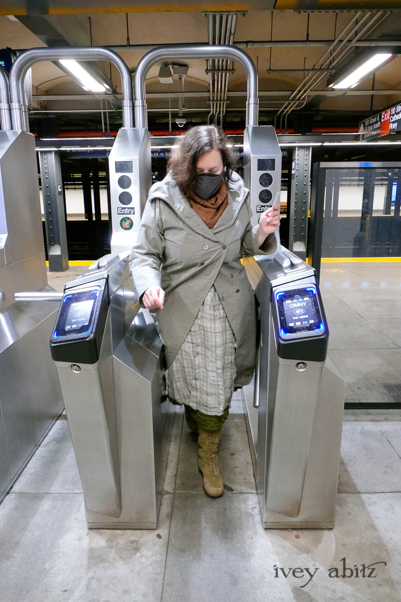 Eleanora Duster Coat in Slate Petite Check Coat Weave; Eleanora Frock in Central Park and Uptown Plaid Linen; Cape Frock in Central Park Washed Linen; Lydia Neck Wrap in Signature Beacon Melange Knit; Bespoke Mask in Slate Washed Knit. - Ivey Abitz Bespoke Clothing