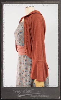Bertie Jacket in New Sun Softest Knit; Floravinea Brooch in Rosy Washed Crinkled Linen; Tilbrook Frock in Fresh Water Floral Weave; Edenshire Frock in New Sun Washed Linen in High Water Length; Porte Cochere Sash in Rosy Washed Cotton. By Ivey Abitz.