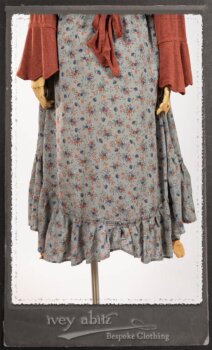 Bertie Jacket in New Sun Softest Knit; Floravinea Brooch in Rosy Washed Crinkled Linen; Tilbrook Frock in Fresh Water Floral Weave; Edenshire Frock in New Sun Washed Linen in High Water Length; Porte Cochere Sash in Rosy Washed Cotton. By Ivey Abitz.