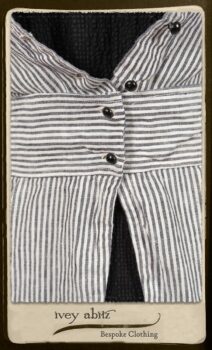 Campanella Shirt Jacket in Black and White Petite Stripe Linen; Bertie Frock in Black Puckered Check Weave; Cilla Slip Frock in Signature Black Lightweight Linen Knit; Floravinea Brooch in Rosy Washed Crinkled Linen. By Ivey Abitz.