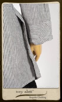 Campanella Shirt Jacket in Black and White Petite Stripe Linen; Bertie Frock in Black Puckered Check Weave; Cilla Slip Frock in Signature Black Lightweight Linen Knit; Floravinea Brooch in Rosy Washed Crinkled Linen. By Ivey Abitz.