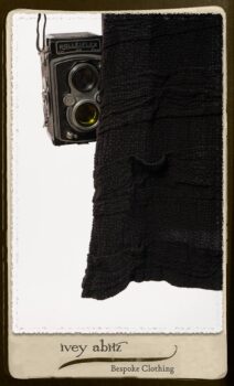 Campanella Shirt Jacket in Black and White Petite Stripe Linen; Bertie Frock in Black Puckered Check Weave; Cilla Slip Frock in Signature Black Lightweight Linen Knit; Floravinea Brooch in Rosy Washed Crinkled Linen. By Ivey Abitz.