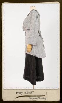 Campanella Shirt Jacket in Black and White Petite Stripe Linen; Bertie Frock in Black Puckered Check Weave; Cilla Slip Frock in Signature Black Lightweight Linen Knit; Floravinea Brooch in Rosy Washed Crinkled Linen. By Ivey Abitz.