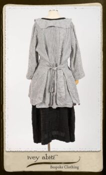 Campanella Shirt Jacket in Black and White Petite Stripe Linen; Bertie Frock in Black Puckered Check Weave; Cilla Slip Frock in Signature Black Lightweight Linen Knit; Floravinea Brooch in Rosy Washed Crinkled Linen. By Ivey Abitz.