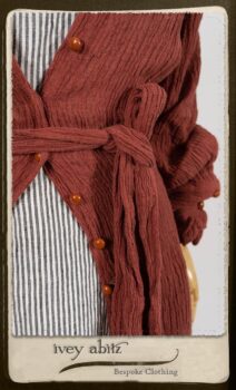 Scattergood Duster Coat in Rosy Washed Crinkled Linen; Scattergood Frock in Black and White Petite Stripe Linen; Floravinea Brooch in Rosy Washed Crinkled Linen. By Ivey Abitz.