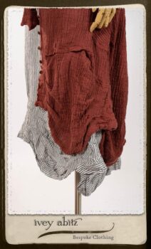 Scattergood Duster Coat in Rosy Washed Crinkled Linen; Scattergood Frock in Black and White Petite Stripe Linen; Floravinea Brooch in Rosy Washed Crinkled Linen. By Ivey Abitz.