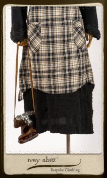 Bramley Frock in Black and White Picture Book Plaid; Clotaire Sash in White on Black Floral Silk Chiffon; Bertie Jacket in Black Floral Raised Knit; Bertie Frock in Black Puckered Check Weave. By Ivey Abitz.