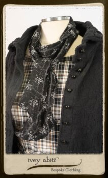 Bramley Frock in Black and White Picture Book Plaid; Clotaire Sash in White on Black Floral Silk Chiffon; Bertie Jacket in Black Floral Raised Knit; Bertie Frock in Black Puckered Check Weave. By Ivey Abitz.