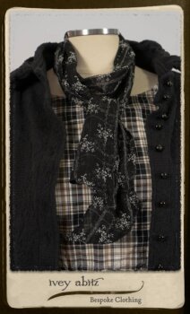 Bramley Frock in Black and White Picture Book Plaid; Clotaire Sash in White on Black Floral Silk Chiffon; Bertie Jacket in Black Floral Raised Knit; Bertie Frock in Black Puckered Check Weave. By Ivey Abitz.