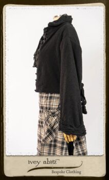 Bramley Frock in Black and White Picture Book Plaid; Clotaire Sash in White on Black Floral Silk Chiffon; Bertie Jacket in Black Floral Raised Knit; Bertie Frock in Black Puckered Check Weave. By Ivey Abitz.
