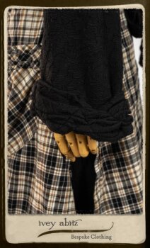 Bramley Frock in Black and White Picture Book Plaid; Clotaire Sash in White on Black Floral Silk Chiffon; Bertie Jacket in Black Floral Raised Knit; Bertie Frock in Black Puckered Check Weave. By Ivey Abitz.
