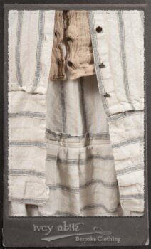 Harrison Duster Coat in Black and White Picture Book Stripe; Harrison Shirt Jacket in Picture Book Washed Crinkled Linen; Clotaire Sash in White on Black Floral Silk Chiffon; Fairholme Frock in Black and White Picture Book Stripe. By Ivey Abitz.