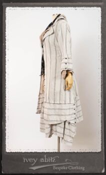 Harrison Duster Coat in Black and White Picture Book Stripe; Harrison Shirt Jacket in Picture Book Washed Crinkled Linen; Clotaire Sash in White on Black Floral Silk Chiffon; Fairholme Frock in Black and White Picture Book Stripe. By Ivey Abitz.