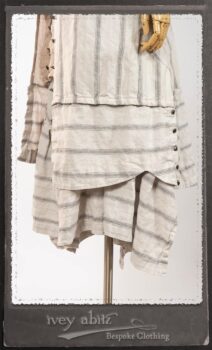 Harrison Duster Coat in Black and White Picture Book Stripe; Harrison Shirt Jacket in Picture Book Washed Crinkled Linen; Clotaire Sash in White on Black Floral Silk Chiffon; Fairholme Frock in Black and White Picture Book Stripe. By Ivey Abitz.