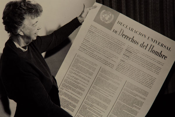 Eleanor Roosevelt holding up a copy of the Declaracion Universal de derechos del Hombre (The Universal Declaration of Human Rights).