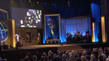 Wide shot of Carolyn on emmys stage