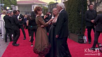 John McCook compliments Carolyn Hennesy on her Ivey Abitz dress on the red carpet.